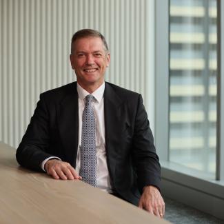 Paul Moore wearing a suit, sitting in an office